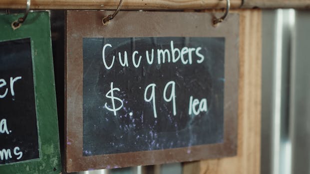 Close-up of a chalkboard sign showing cucumbers priced at 99 cents each.
